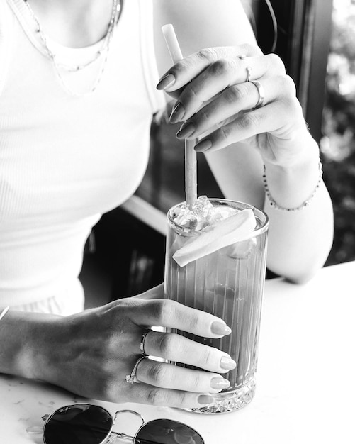 Foto ijskoffie met melk. ijskoffie latte. vrouw met glazen kopje ijskoffie.