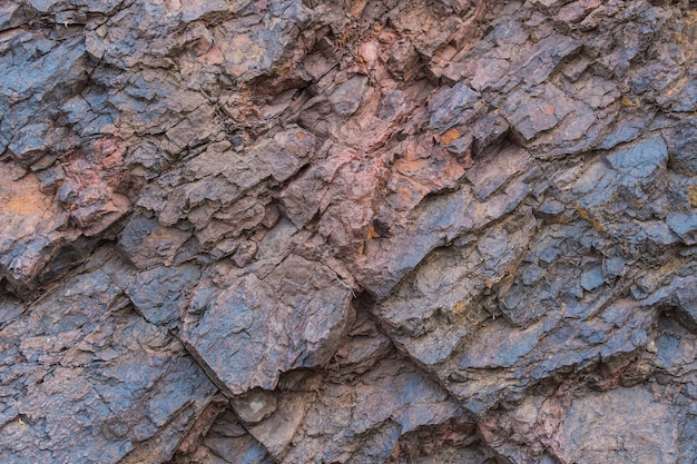 Foto ijzererts textuur close-up - natuurlijke mineralen in de mijn. steentextuur van open kuil. winning van mineralen voor de zware industrie - de textuur van het gesteente dat ijzererts en koper bevat.
