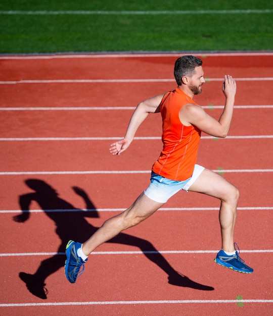 Ik ben de beste atletische man die deelneemt aan sprintsport gezonde levensstijl fitness training outdoor loper snel rennen op de atletiekbaan energiek en sportief marathonsnelheid energie gespierde man in beweging