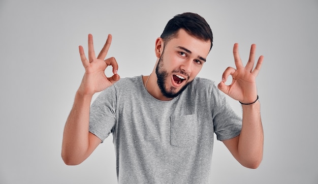 Ik ben ok. Gelukkig zakenman, teken ok, glimlachend, geïsoleerd op grijze studio achtergrond. Mooi mannelijk portret van halve lengte. Emotionele mens. Menselijke emoties, gezichtsuitdrukking concept. Voorkant