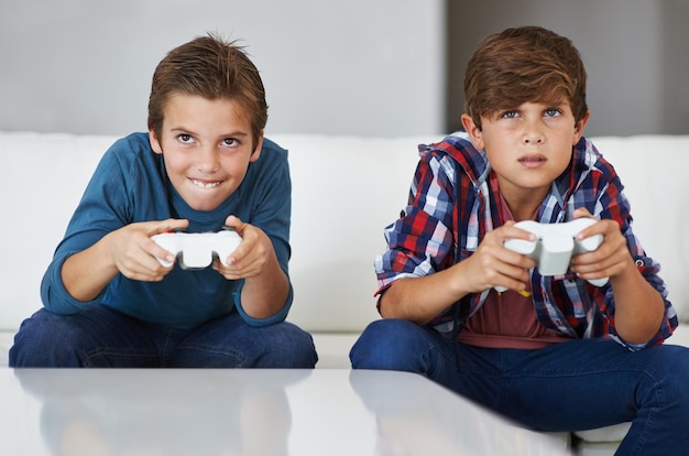 Ik ga je verslaan Shot van twee jonge jongens die zich concentreren tijdens het spelen van videogames