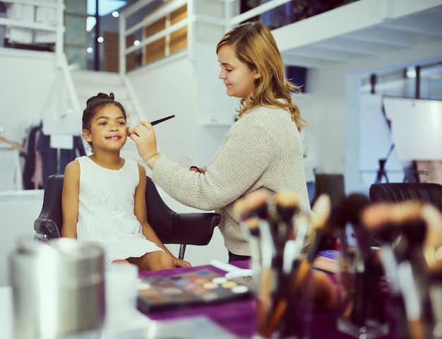 Foto ik ga vandaag die kroon winnen shot van een stylist die make-up aanbrengt op een schattig klein meisje in een kleedkamer