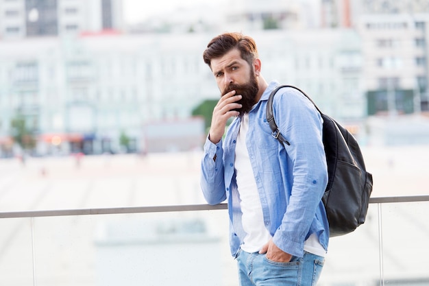 Ik geef de voorkeur aan actieve vakanties. Hipster op vakantiereizen. Bebaarde man reizen met rugzak op zomervakantie. Backpacker die op vakantie gaat. Toerist of reiziger backpacken door de stad.