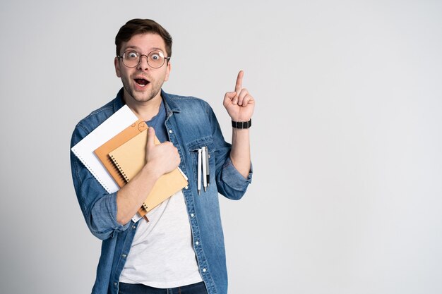 Ik heb een briljant idee. Blanke vrolijke man, werpt wijsvinger, heeft intrigerend plan geïsoleerd met kopie ruimte Knappe slimme student draagt ronde bril