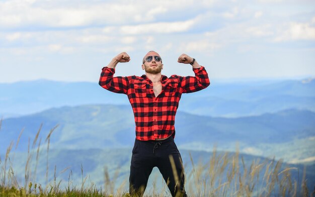 Ik heb macht sexy macho man in geruit overhemd reizen avontuur hipster mode man op berglandschap kamperen en wandelen cowboy in hoed buiten platteland concept boer op rancho