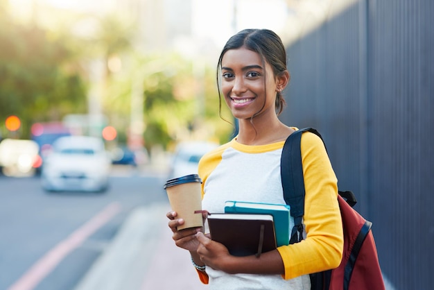 Ik heb mijn boeken en koffie Ik ben klaar voor de universiteit Bijgesneden opname van een jonge vrouwelijke student die naar de universiteit in de stad pendelt