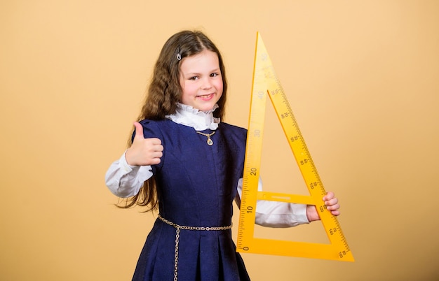 Ik hou van wiskunde Onderwijs- en schoolconcept Slim en slim concept Leerling schattig meisje met grote liniaal Schoolstudent studie geometrie Maatvoering en meten Kid schooluniform houd liniaal