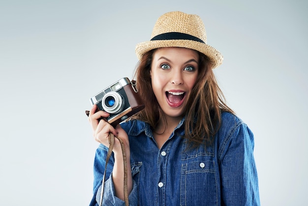 Ik kan me geen spannender moment voorstellen Studioportret van een jonge vrouw die een vintage camera gebruikt tegen een grijze achtergrond