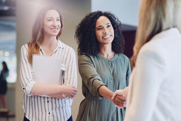 Ik kijk ernaar uit om met je samen te werken Bijgesneden opname van twee jonge zakenvrouwen die elkaar de hand schudden tijdens een vergadering in de bestuurskamer