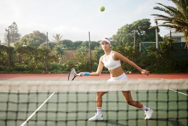 Ik laat het racket het woord doen. Shot van een aantrekkelijke jonge vrouw die buiten tennis speelt.