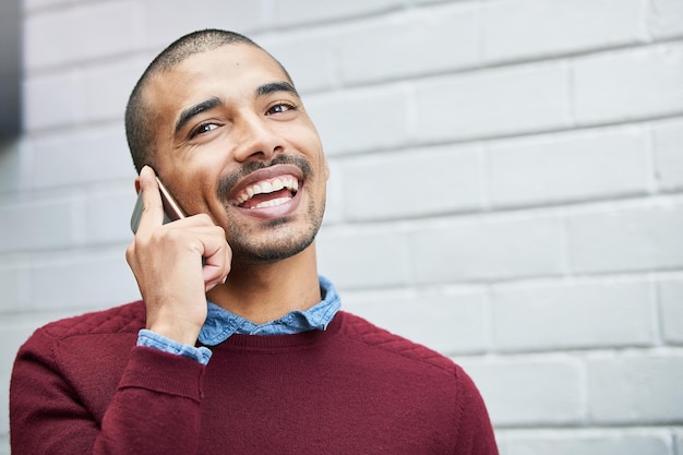 Ik loop nu terug naar mijn kantoor Bijgesneden opname van een jonge zakenman die buiten op een mobiele telefoon praat