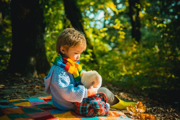 Ik zal je de schoonheid van de natuur laten zien onafscheidelijk met speelgoed jongen schattig kind spelen met teddybeer bosachtergrond kind nam favoriete speelgoed mee naar de natuur picknick met teddybeer wandelen met favoriet speelgoed