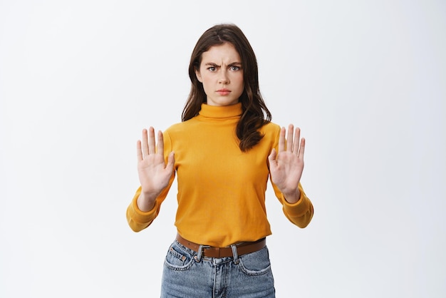 Ik zei nee Ernstige en boze vrouw die fronst en een stopgebaar toont om iets slechts te verbieden, een slecht aanbod weigert en blokkeert dat tegen een witte achtergrond staat