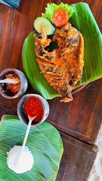Foto ikan bakar bali balinese maaltijd van char gegrilde snappervis met zoete zout en pittige saus