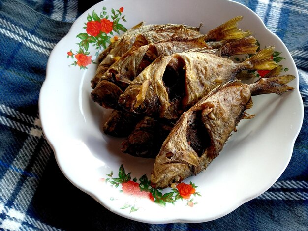 Ikan Goreng or fried fish on a plate Traditional Indonesian culinary food