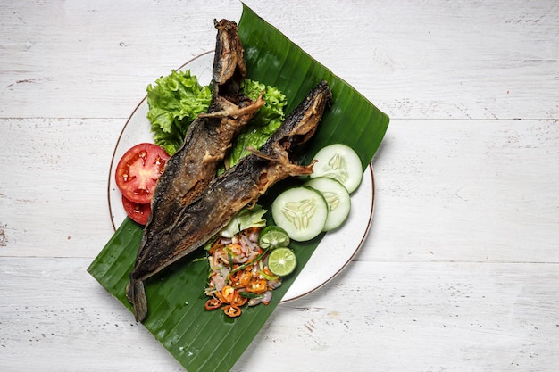 Ikan Lele Goreng with sambal matah fried catfish with Indonesian sambal and herbs