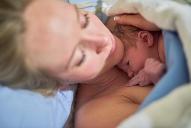 Foto conserverò per sempre questo dono della vita inquadratura di una bellissima giovane madre sdraiata a letto con la sua bambina appena nata in ospedale