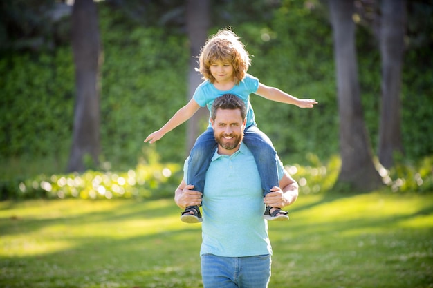 Ill give a piggy-back ride. Happy man carry son sitting on shoulders. Happy kid ride piggy-back