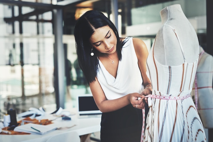 Photo ill have to take a few inches off shot of a successful young fashion designer working on her latest design