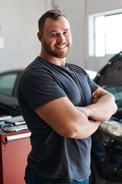 Ill have your car running like new again Shot of a mechanic posing with his arms crossed in an auto repair shop