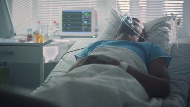 Photo ill patient breathe oxygen mask in emergency room modern hospital ward interior