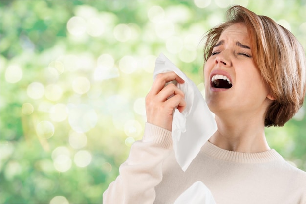 Ill woman with napkin sneezing