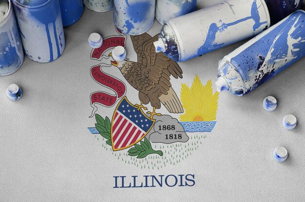 Illinois us state flag and few used aerosol spray cans for graffiti painting street art culture conc