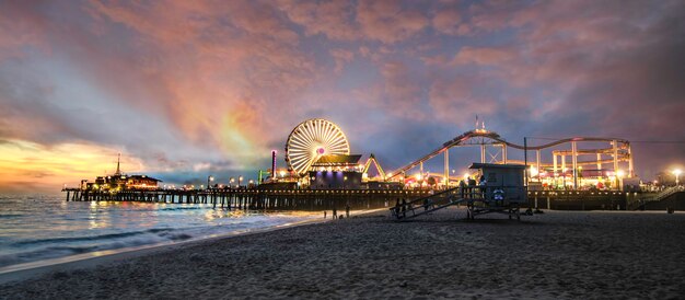 写真 夜の空に照らされた海辺の遊園地