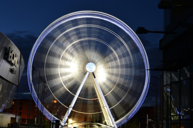 Foto ruota panoramica sfocata illuminata contro il cielo