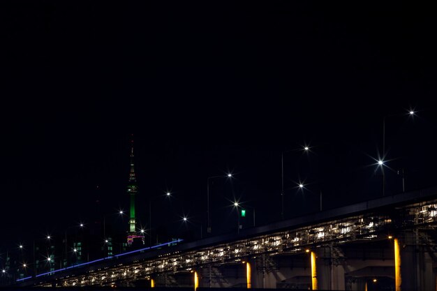 illuminated bridge against sky at night