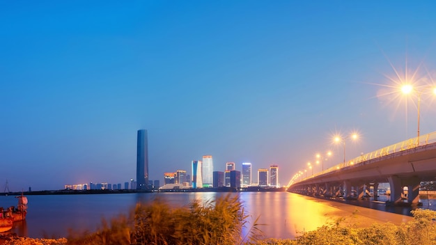 Photo illuminated bridge by river against clear sky in city at dusk