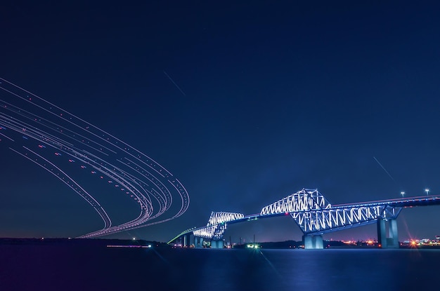 写真 夜の空に照らされた川を越えた橋