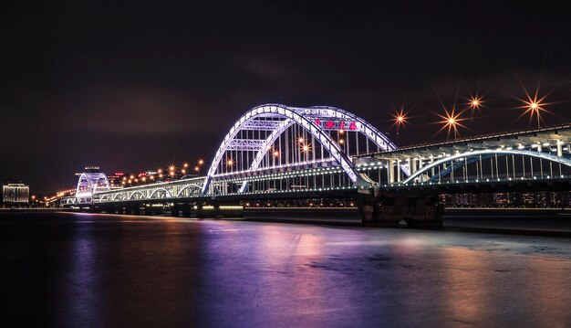 写真 夜に川を渡る照らされた橋