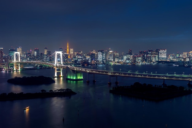 Illuminated bridge over river against sky in city at night