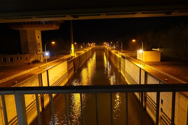 Illuminated bridge over river against sky at night