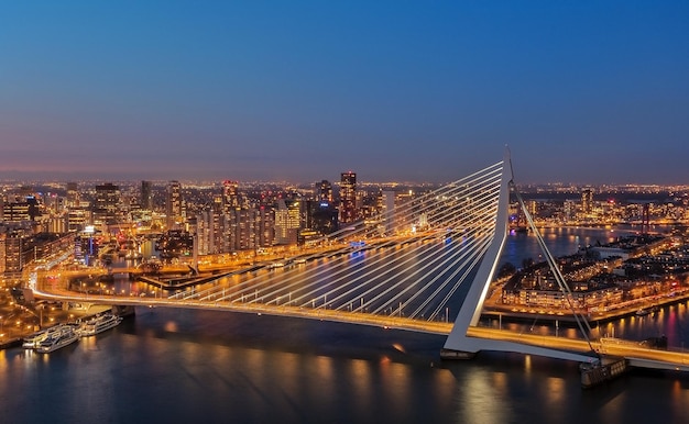 Illuminated bridge over river in city against sky at night
