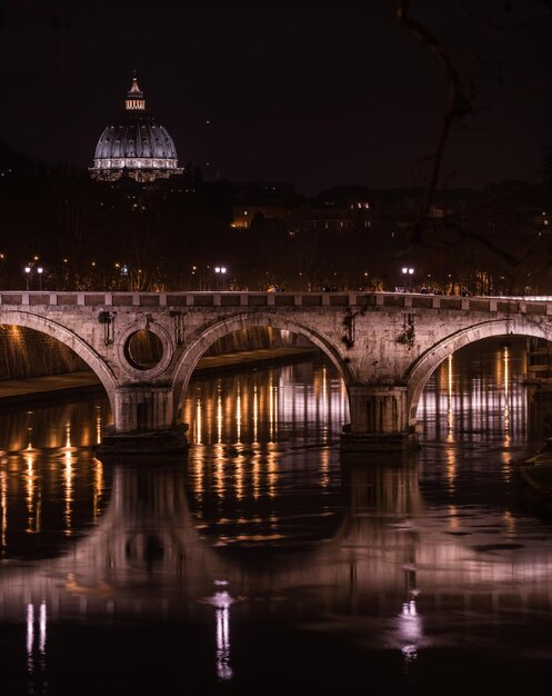 Photo illuminated bridge over river in city at night