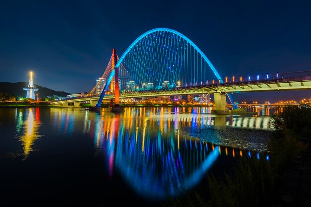 Illuminated bridge over river at night