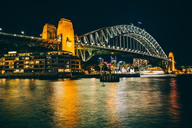 Photo illuminated bridge over river at night