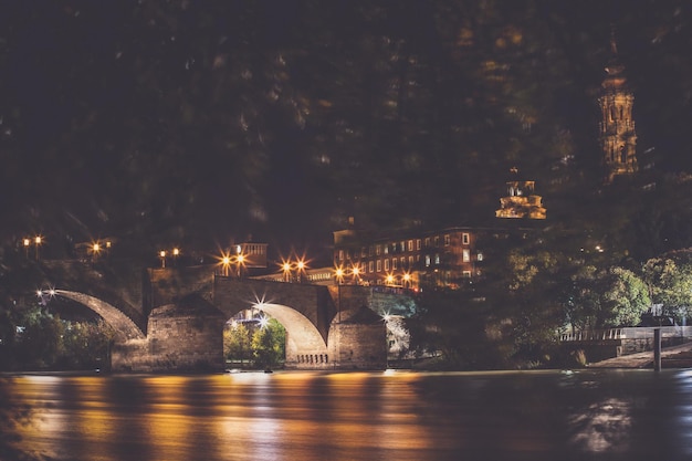 Освещенный мост через реку ночью