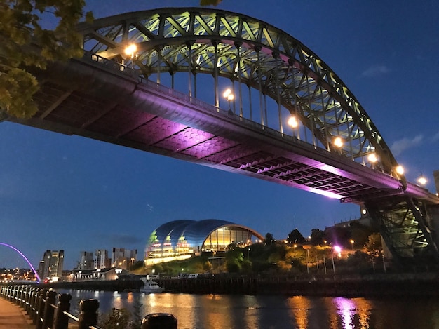 Photo illuminated bridge over river at night