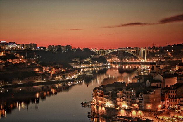 Photo illuminated bridge over river at sunset