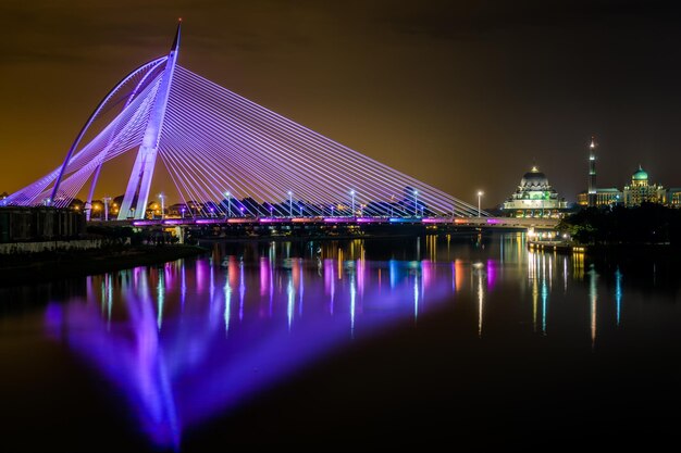 Illuminated bridge over water at night