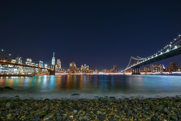 Illuminated bridges over east river against sky at night