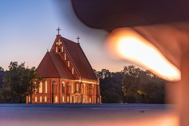 Photo illuminated building against sky during sunset