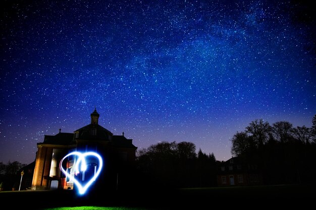 Photo illuminated building against sky at night