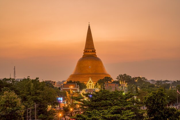 Illuminated building against sky during sunset