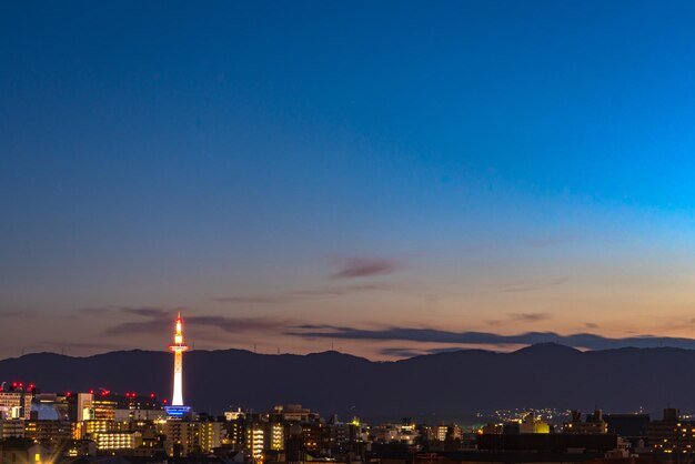 Illuminated buildings against sky at sunset