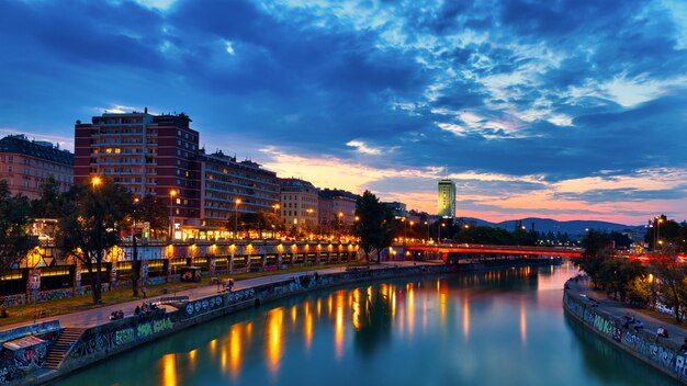 写真 夕暮れの空に照らされた川沿いの建物