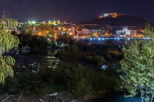 Illuminated buildings by river at night